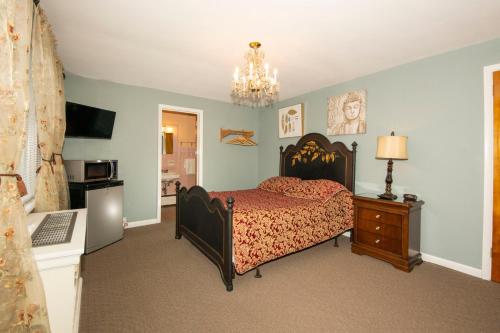 a bedroom with a bed and a chandelier at Simmons Motel and Suites in Hershey