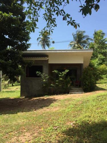 a small house in the middle of a field at DG House in Thongsala