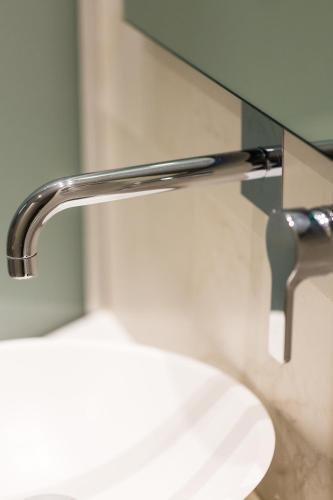a bathroom sink with a faucet and a mirror at Radamanthy's Hotel Apartments in Sfakaki