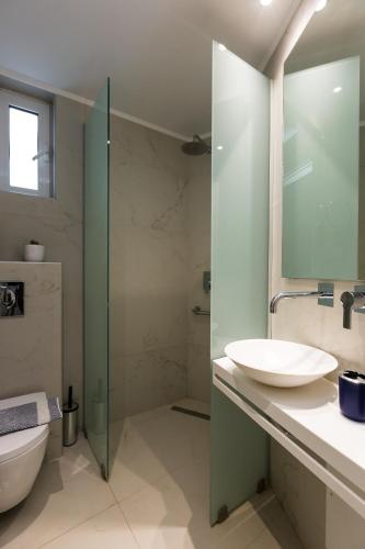 a bathroom with a sink and a toilet at Radamanthy's Hotel Apartments in Sfakaki