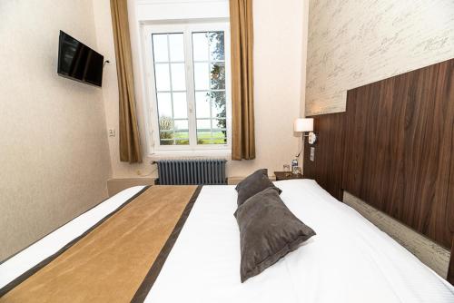a bedroom with a large bed and a window at Logis - Hotel Restaurant La Sapinière in Wisques