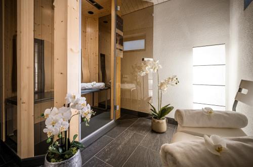 a living room with white flowers in a room at Golf- & Sporthotel Hof Maran in Arosa