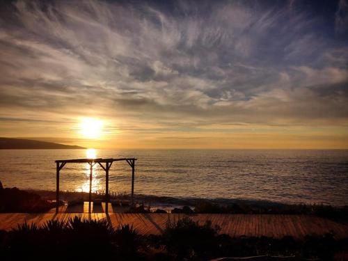 a sunset on the beach with the sun setting over the ocean at Beach & Surf in Ribeira Grande