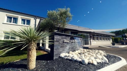 a flock of sheep sitting in front of a building at Citotel Hôtel Le Capricorne in Marmande