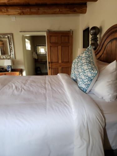 a bedroom with a white bed with a wooden headboard at Abiquiu Inn in Abiquiu