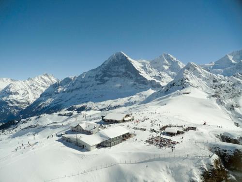 a group of people standing on top of a snow covered mountain at Berghaus Männlichen in Grindelwald