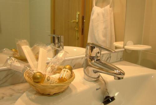 a bathroom sink with a basket on the sink at Aparthotel Encasa in Madrid