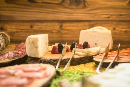 a table topped with cheese and meats and desserts at Serendipity Hotel in Sauze dʼOulx