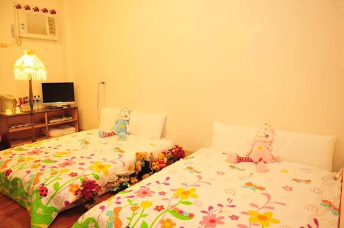 a bedroom with two beds with stuffed animals on them at Relax heart B&B in Dongshan