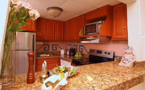 a kitchen with wooden cabinets and a bowl of food on a counter at Paradise Village in Nuevo Vallarta 