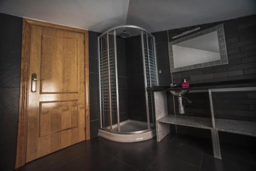 uma casa de banho com um chuveiro e uma porta de madeira em Palacete em Barcelona
