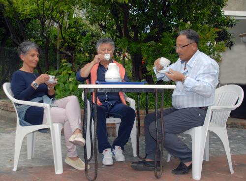 a group of three people sitting at a table drinking coffee at Casalbergo700 in Marina di Fuscaldo