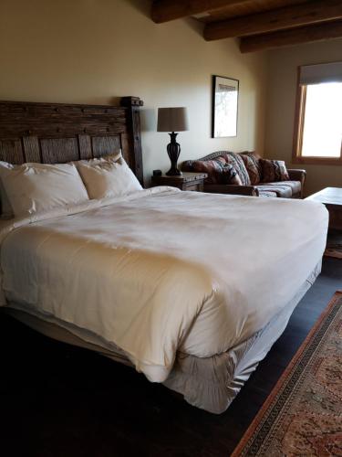 a bedroom with a large white bed and a couch at Abiquiu Inn in Abiquiu
