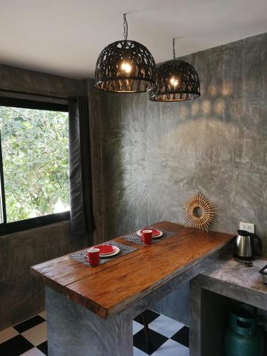 a table in a kitchen with two red cups on it at DG House in Thongsala