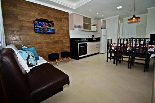 a living room with a couch and a dining room at Morada Pinheiro 160m da Praia in Bombinhas