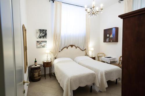 sypialnia z 2 łóżkami i białymi kocami w obiekcie Gourmet B&B Villa Landucci we Florencji