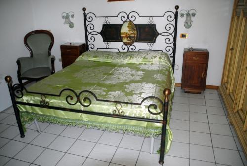 Casalbergo700 في مارينا دي فوسكالدو: غرفة نوم بسرير اخضر وكرسي