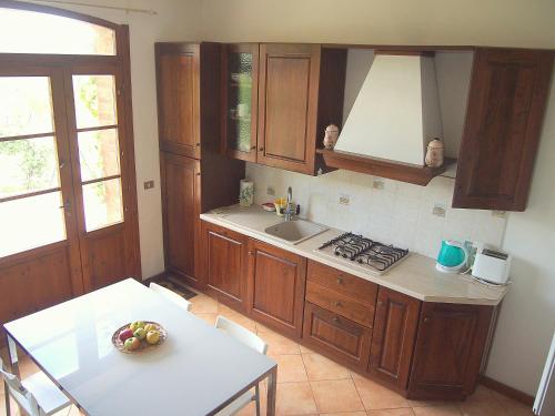 a kitchen with wooden cabinets and a sink and a table at Nell'Antica Torre di Fronte a Siena in Siena
