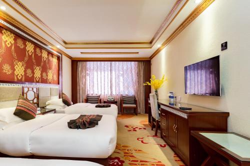 a living room with two white couches and a television at Floral Hotel · Shangri-la Blue Sky in Shangri-La