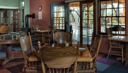 a dining room with tables and chairs and windows at Abiquiu Inn in Abiquiu