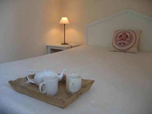 taca z dwoma kubkami na łóżku w obiekcie Le Mazot - Avoriaz w mieście Avoriaz