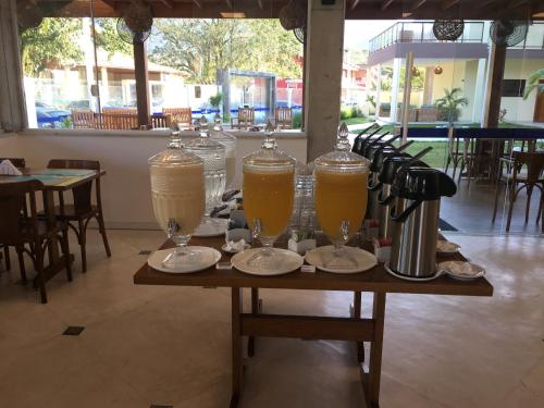 a table with three pitchers of orange juice on it at Pousada Ilha Vitoria in Ubatuba