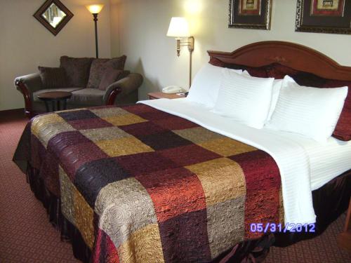 a hotel room with a large bed and a couch at All American Inn & Suites Branson in Branson