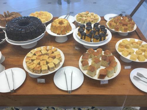 a table full of pies and other desserts on plates at Pousada Ilha Vitoria in Ubatuba