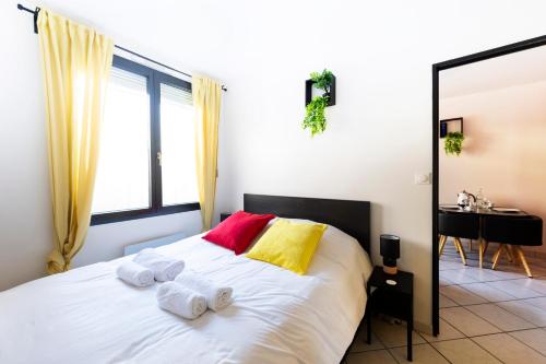 une chambre avec un lit avec des serviettes dessus dans l'établissement Appartement entier - Le mondrian - 1ch Check-in 24h, à Villeurbanne