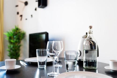 - une table avec des verres à vin et une bouteille dans l'établissement Appartement entier - Le mondrian - 1ch Check-in 24h, à Villeurbanne