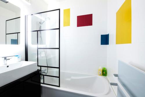 une salle de bain avec un lavabo et une baignoire dans l'établissement Appartement entier - Le mondrian - 1ch Check-in 24h, à Villeurbanne