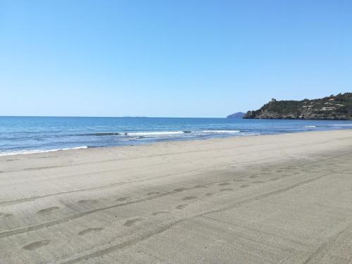 a beach with footprints in the sand and the ocean at "IL CASALE DEI GIRASOLI" Country House in Capalbio in Capalbio