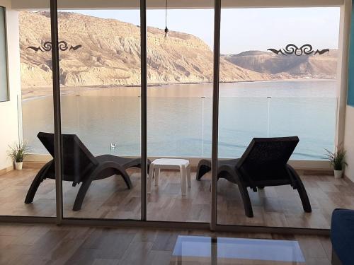 two chairs and a table in front of a large window at Imsouane Magic House in Imsouane