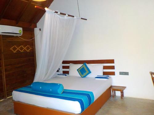 a bedroom with a bed with a wooden headboard at Liyana Holiday resort in Anuradhapura
