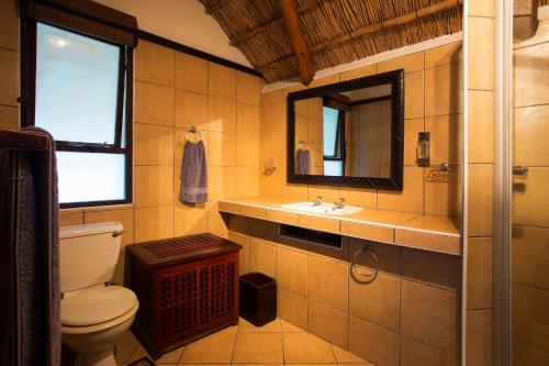 a bathroom with a toilet and a sink and a mirror at Vila Do Paraiso in Vilanculos