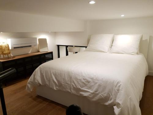 - une chambre avec un lit blanc et un bureau avec une imprimante dans l'établissement Loft Luxe Liberté 2, à Marseille