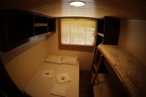 a small room with a bed and a window at Tapri - Hotel Flutuante in Barra Bonita