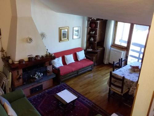 a living room with a red couch and a table at Monte Cervino apartment AS14 in Breuil-Cervinia