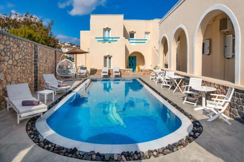 
a swimming pool with a blue and white pool table and chairs at Alizea Villas & Suites in Fira
