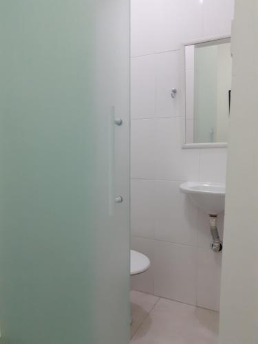 a white bathroom with a sink and a toilet at Copacabana Beach Modern Apartments in Rio de Janeiro