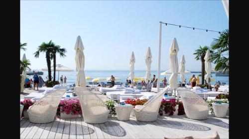 a group of white chairs and tables on a beach at Arcadia in Odesa