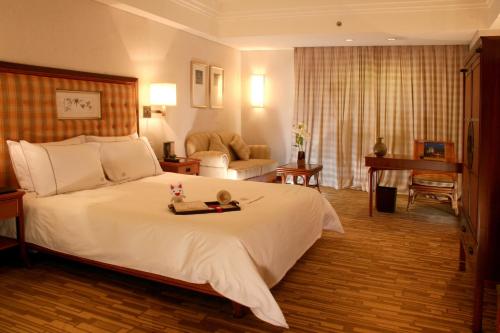 Huizhou Kande International Hotel في هويزو: غرفة نوم بسرير كبير وغرفة معيشة