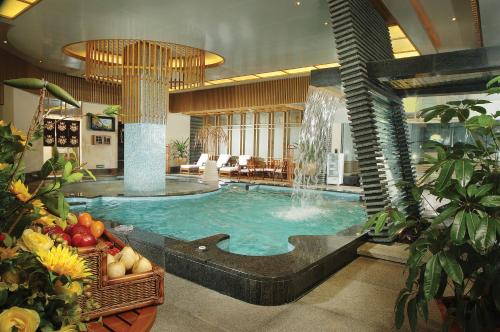 uma grande piscina com uma fonte num quarto de hotel em Huizhou Kande International Hotel em Huizhou