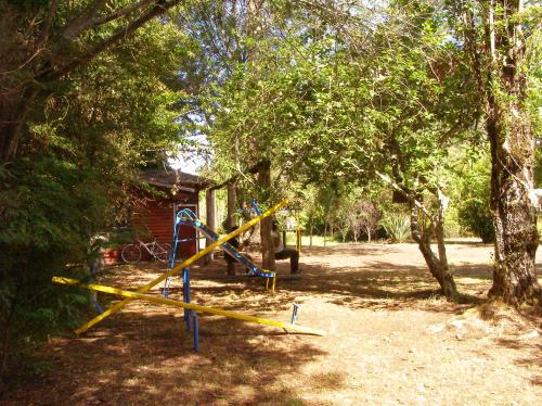 a playground in a yard next to a tree at Cabañas Vista al Lago in Ensenada