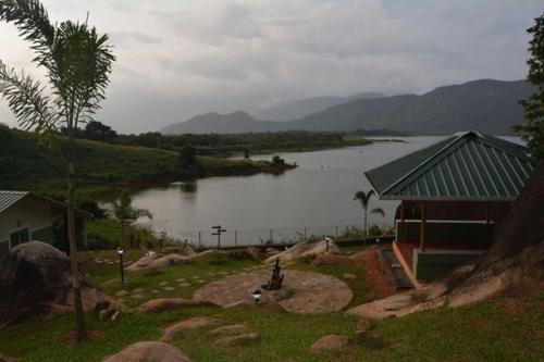 a view of a lake with a building and a house at Diga vista resorts in Palakkad