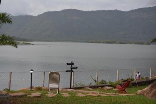 two chairs sitting next to a body of water at Diga vista resorts in Palakkad
