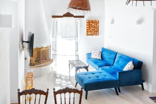 a living room with a blue couch and chairs at SeaScapeHome Serifos in Serifos Chora