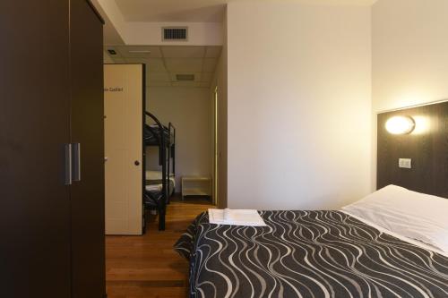 a hotel room with a bed and a hallway at Daglingegneri in Pisa