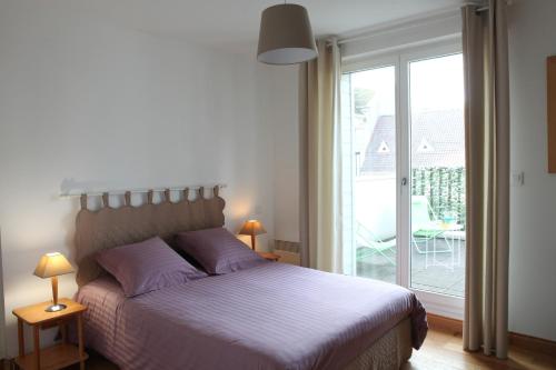 a bedroom with a bed and a sliding glass door at Cape Cod in Wimereux