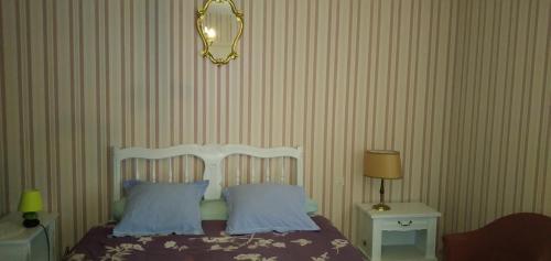 a bedroom with a bed with two pillows and a mirror at chambre d'hôte in Campagne
